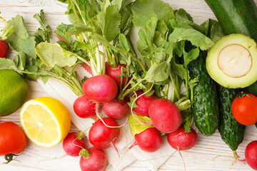 Radish and other spring vegetables on a wooden background. Top view.