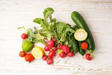 Radish and other spring vegetables on a wooden background, top view.