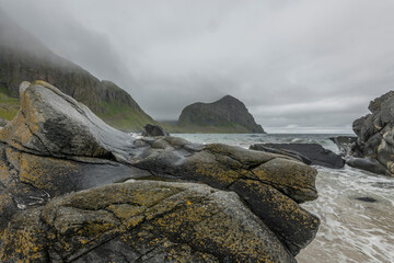 View on a rocky beach on Vaeroy island ( Værøy ) on Lofoten archipelago with a moody stormy sky. Boulders, rocks, Norway, wilderness. Bad weather. day, summer.