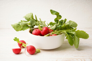 Ripe red radish in a bowl on wooden background. Fresh red radish..