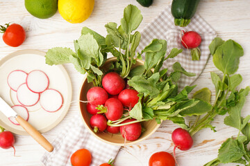 Radish and other spring vegetables on a wooden background, top view.