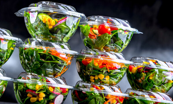 Boxes with pre-packaged vegetable salads in a commercial fridge