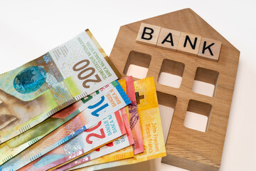 Miniature bank of switzerland and a bundle of swiss francs, business concept, banking business,...