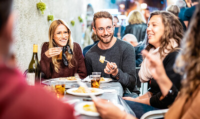 Trendy people having fun drinking white wine at street food event - Happy friends eating local meal...