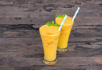 Mango juice fruit smoothies yogurt drink yellow healthy delicious taste in a glass slush for weight loss on wooden background.