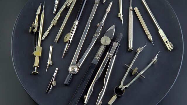 Compass for drawing. Set of old different compasses. Retro metal compasses and drafting tools on a black background. Drawing pen. Tool for study draw