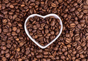 Coffee beans and a plate in the shape of a heart.Coffee beans in the shape of a heart.Flet ley.  © Olivka888