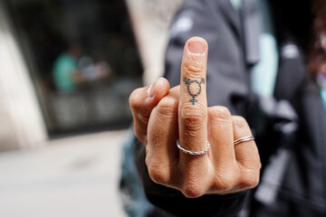 a tattoo of a gender and sexual identity sign on the heart finger. Gay pride day