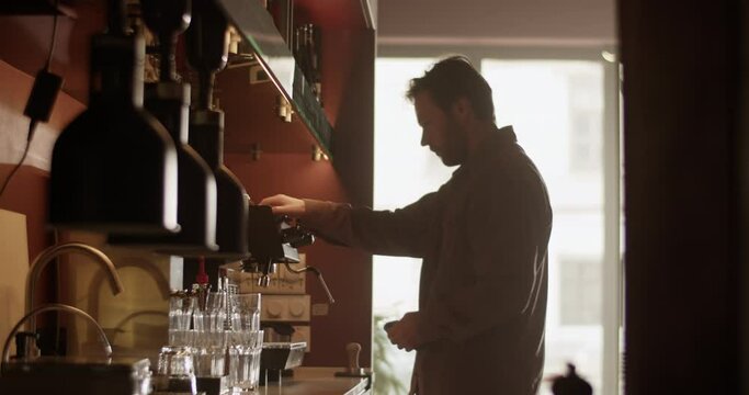 Male bar owner cleaning coffee machine