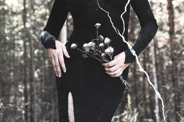 Beautiful faceless woman in black tight dress with dried flowers in hands in the black forest, film...