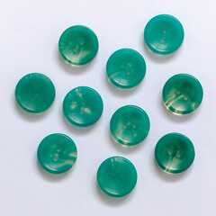 Many turquoise plastic buttons on a white background. Top view. Close up.
