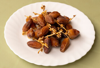 Dates or dattes palm fruit in white bowl is snack healthy, Set of various dates in plate, Different kind of raw date fruit ready to eat, concrete background, Traditional, delicious and healthy ramadan