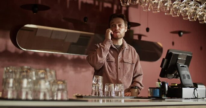 Male bar owner taking reservations by phone