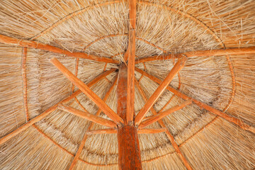 palapa sun roof beach umbrella by the beach symbolizes relaxation, shade, and protection. It...