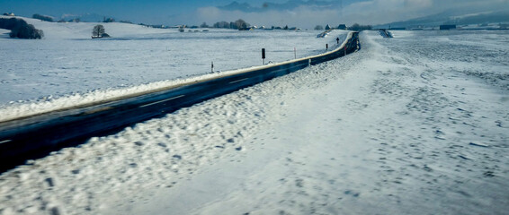 Switzerland, Basel, snow on the countyside with a road in between