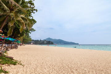 Beautiful Surin beach in Choeng Thale city, Phuket, Thailand with white sand, turquoise water and palm trees