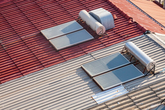 panel of solar boilers are installed on the roof of the house, on a sunny day against a blue sky and sea