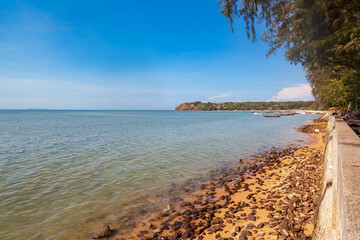 Obraz premium Sea view from rawai beach promenade with rocks and clear water under blue sky