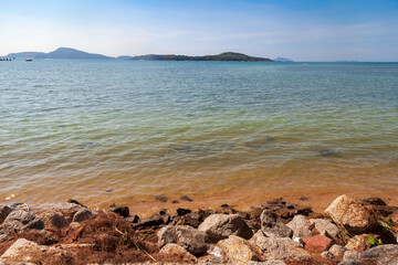 Fototapeta na wymiar Sea view from rawai beach promenade with rocks and clear water under blue sky