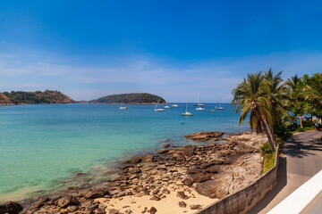 beautiful bright nai harn beach in thailand on phuket island with clear turquoise water in the sea, yachts, white sand and blue sky. A popular tourist place in the hot countries of Asia.