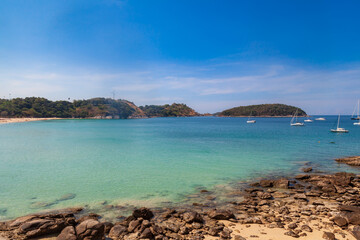 Fototapeta premium beautiful bright nai harn beach in thailand on phuket island with clear turquoise water in the sea, yachts, white sand and blue sky. A popular tourist place in the hot countries of Asia.