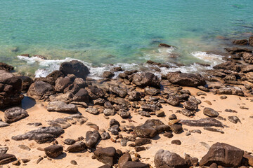 Seashore with sand stones and turquoise clear water on the beach. Tourist travel to thailand on nai harn beach
