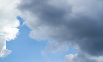 Summer sky. Cumulus clouds on a blue background. Partly cloudy.