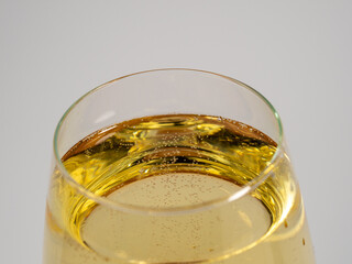 A glass of white wine on a light background.