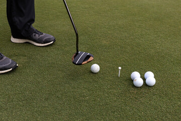 Golf lesson for beginners, golf balls and club and tee.