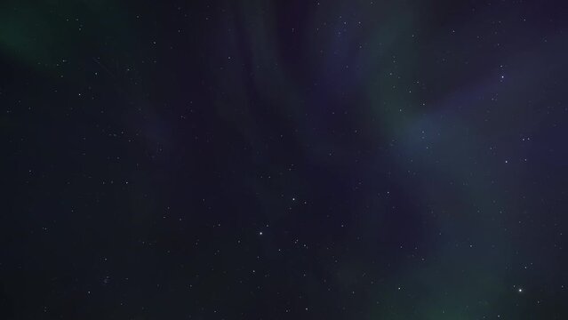 Northern Lights (Aurora Borealis) appear overhead on the night sky. Timelapse. 