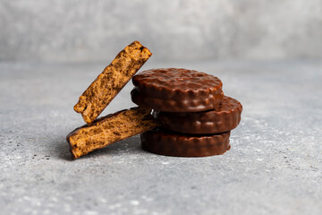 Delicious chocolate cookies stack and broken in half lies against a gray spotted background