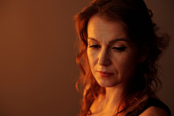 Stressed sad mature woman looking down thinking about her problems