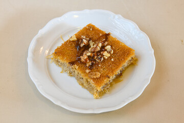 Pistachio kadayif on a plate. Turkish Dessert Kadayif with pistachio powder. Kunefe. Local name burma kadayif