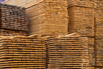 Wooden boards, lumber, industrial wood, timber. Pine wood timber stack of natural rough wooden boards on building site. Industrial timber building materials