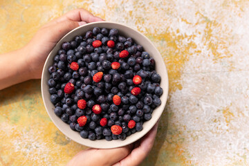 Strawberries and blueberries in bowl on a rustic wooden table. These super-food berries are part of a healthy diet promoting a healthy heart and well being.Big Pile of Fresh Berries