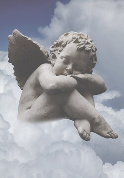 A little angel sleeps on a cloud. Vertical image.