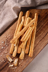 bread sticks with sesame seeds on a wooden board, top view