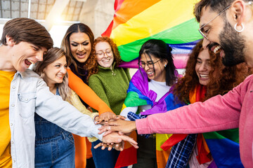 Homosexual diverse group of young people stacking hands together outdoors. LGBTQ community concept with multiracial friends celebrating gay pride festival day. - Powered by Adobe
