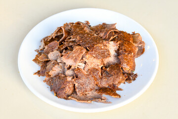 Turkish and Arabic Traditional Ramadan doner kebab with tasty tomato sauce and rice or turkish pilav in white plate on wood table background. ( Pilav ustu doner)