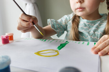 Little child draws with watercolor, concept of education in the kindergarten