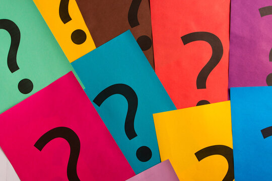 Black question marks on the colored papers