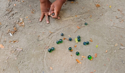 Hand of kids playing marbles. Childhood memories.
