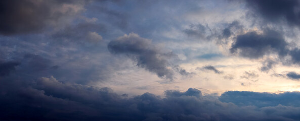 Naklejka na ściany i meble Dark sky with heavy clouds, illuminated by the evening sun