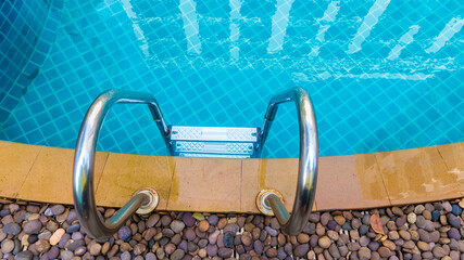 Ladder stainless handrails for descent into swimming pool. Swimming pool with handrail . Ladder of...