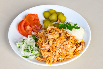Turkish and Arabic Traditional Ramadan doner kebab with tasty tomato sauce and rice or turkish pilav in white plate on wood table background. ( Pilav ustu doner)