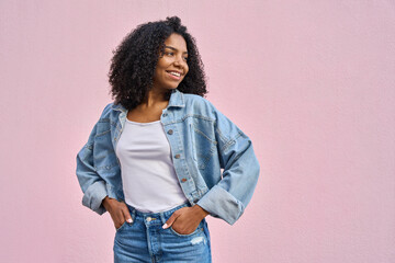 A cheerful stylish hipster teenage female girl in jeans jacket looking aside with copy space. A...