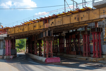 Subway bridge under construction above empty riad in summer city against blue sky with few clouds....