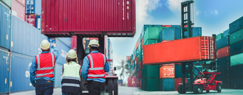 Industrial worker works with co-worker at overseas shipping container yard. Logistics supply chain management and international goods import and export concept. Business logistic concept. cargo.