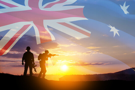 Silhouettes of soldiers on background of Australia flag and the sunset or the sunrise background. Anzac Day. Remembrance Day.