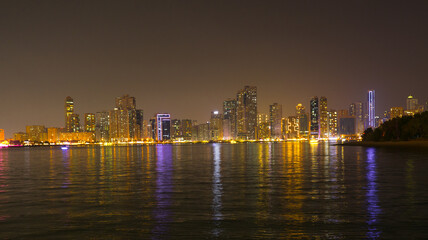 Obraz premium Night landscape of the embankment of the emirate of Sharjah, United Arab Emirates